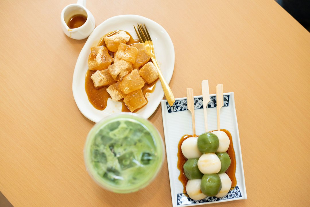 Postres japoneses con matcha: dorayaki relleno en plato blanco, bolitas de mochi alternadas con crema, salsa de soja y pasta